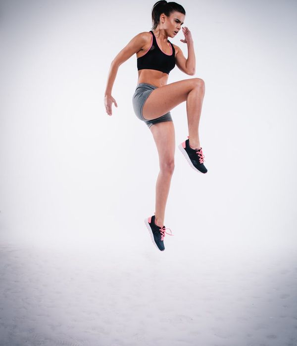 Energetic woman jumping joyfully during a cardio workout.